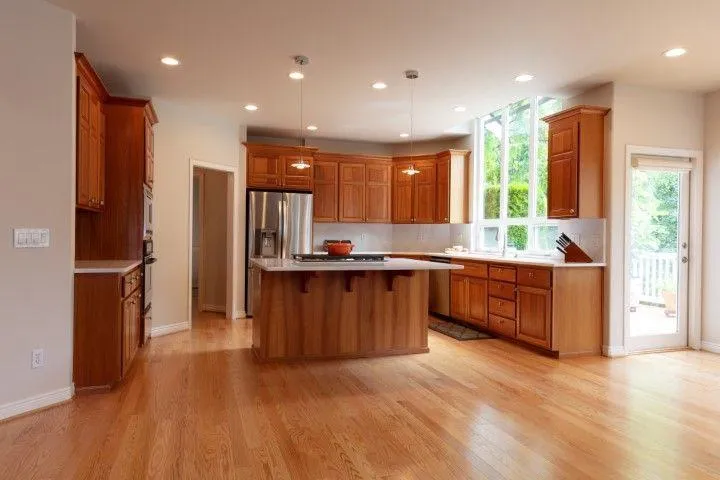Spacious custom kitchen featuring rich wooden cabinetry and an island by Fort Washington Carpentry Craftsmen