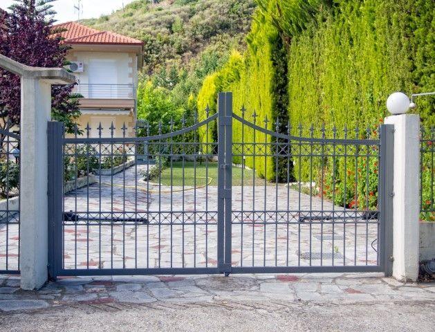 Sandusky Fencing Creations in Sandusky OH installing a custom wrought iron driveway gate.
