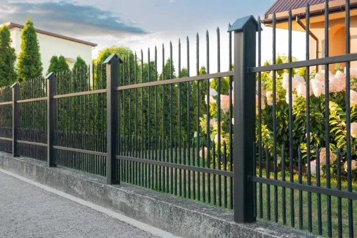 Sandusky Fencing Creations in Sandusky OH showcasing a black metal fence installed on a concrete wall.