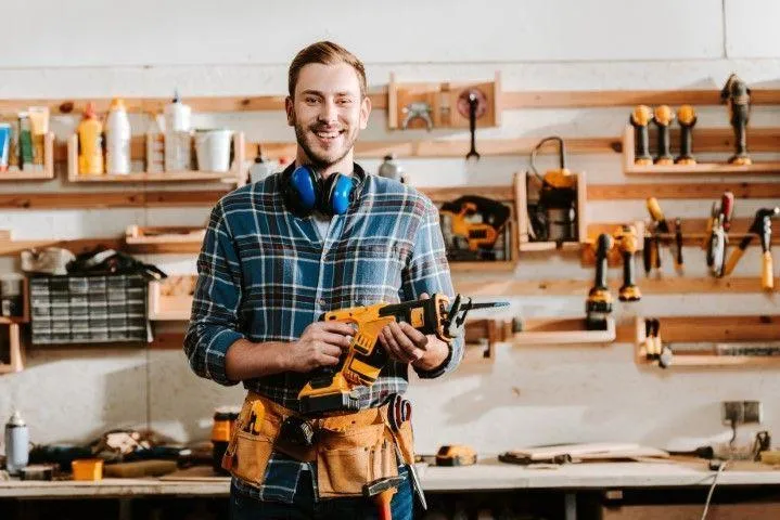 Wethersfield Carpentry Masters in Wethersfield CT carpenter holding a cordless saw in a wood workshop.