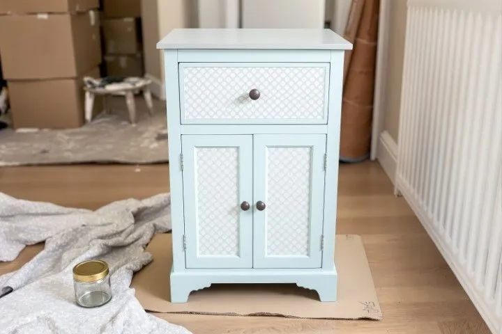 A small, newly painted light blue cabinet with decorative patterned panels, a DIY project by Custom Carpentry Creations in Clovis.