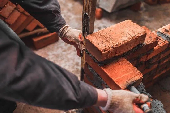 Clarington Masonry Craftsmen in Clarington ON using a level tool to ensure perfectly straight red bricks.