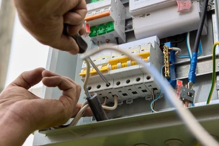 Grandview Electrical Pro in Grandview MO expertly upgrading and screwing connections inside a circuit breaker panel.