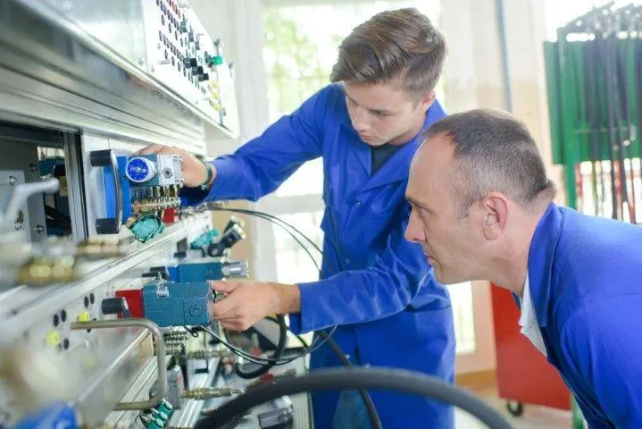 Two technicians working on an industrial electrical control panel for Falls Electric Services Company in Falls PA.