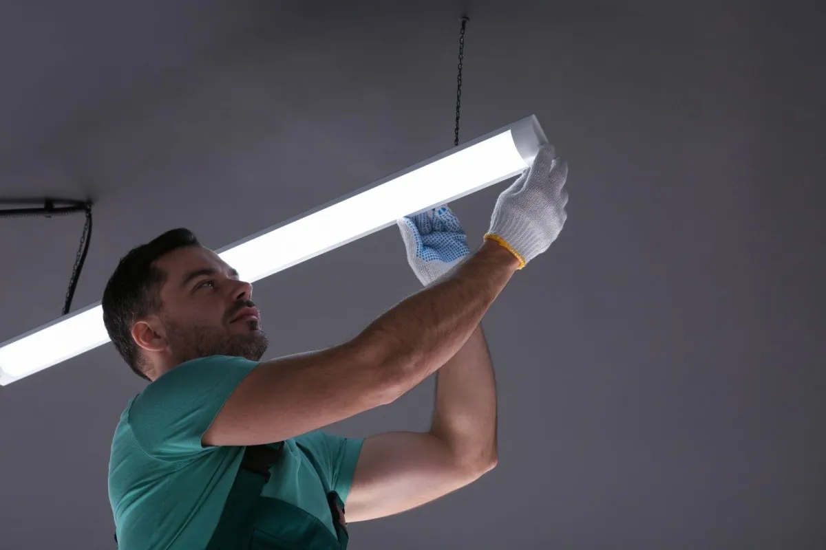 Grandview Electrical Pro in Grandview MO installing a long LED ceiling light fixture indoors.