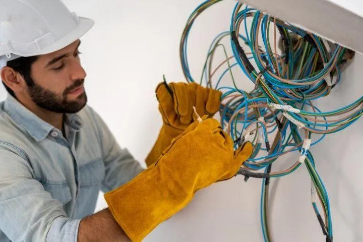 Grandview Electrical Pro in Grandview MO working with a complex bundle of colorful electrical wiring.
