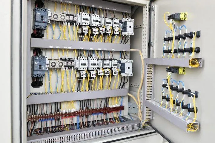Grandview Electrical Pro in Grandview MO inspecting a clean, highly organized industrial electrical control panel.