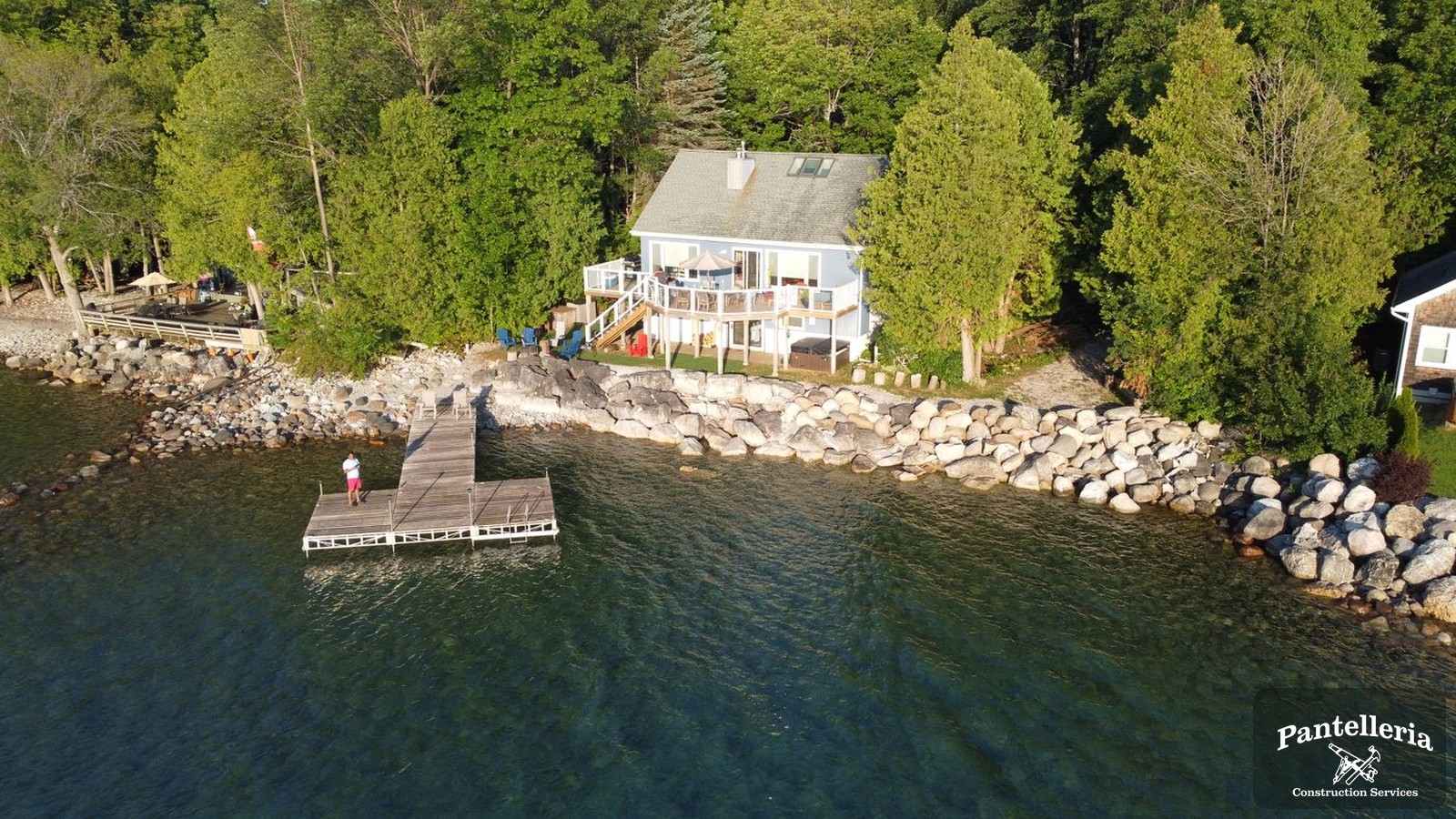 Lakeshore home with a deck and private dock on a wooded Great Lakes shoreline