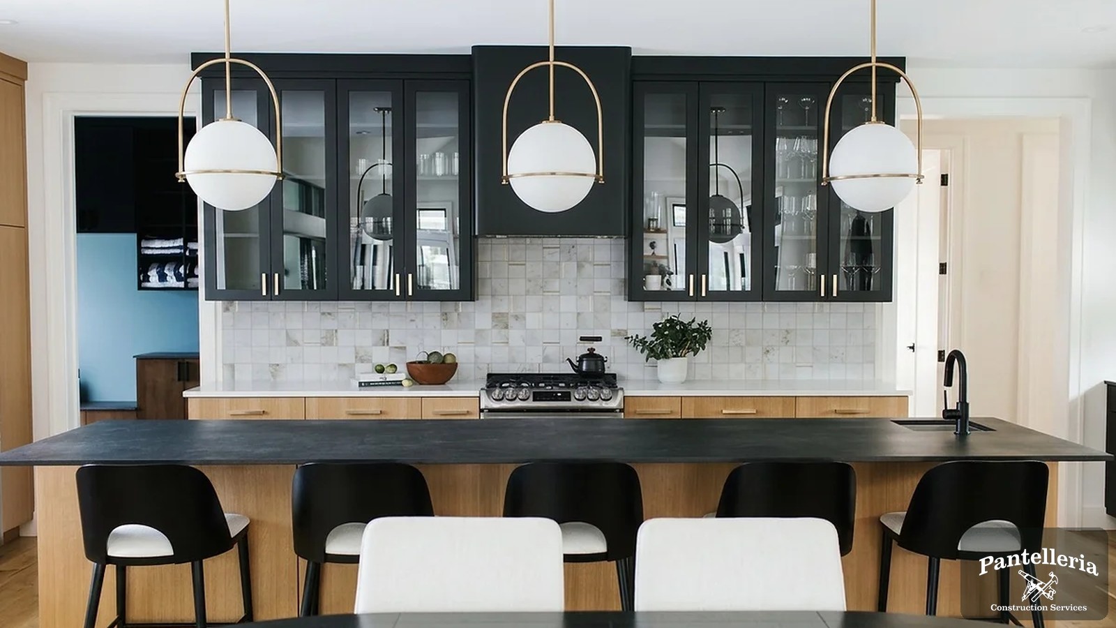 Custom kitchen with dark upper cabinetry, white oak island and quartz counters built by Pantelleria Construction in Southwest Michigan