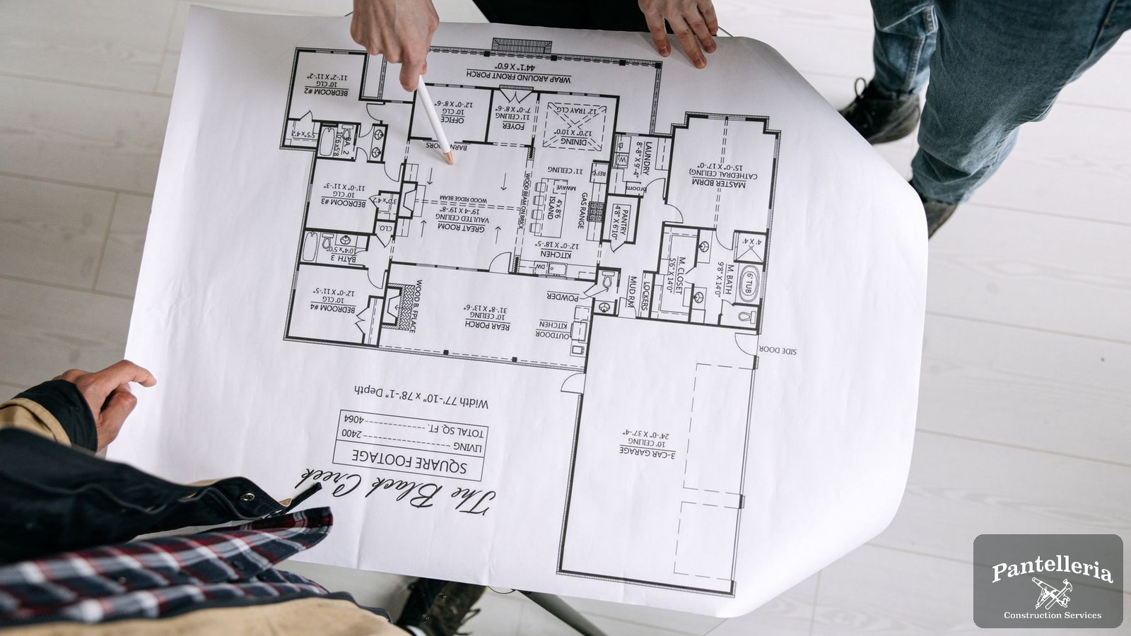 Builder and homeowner reviewing a custom home floor plan together on a table