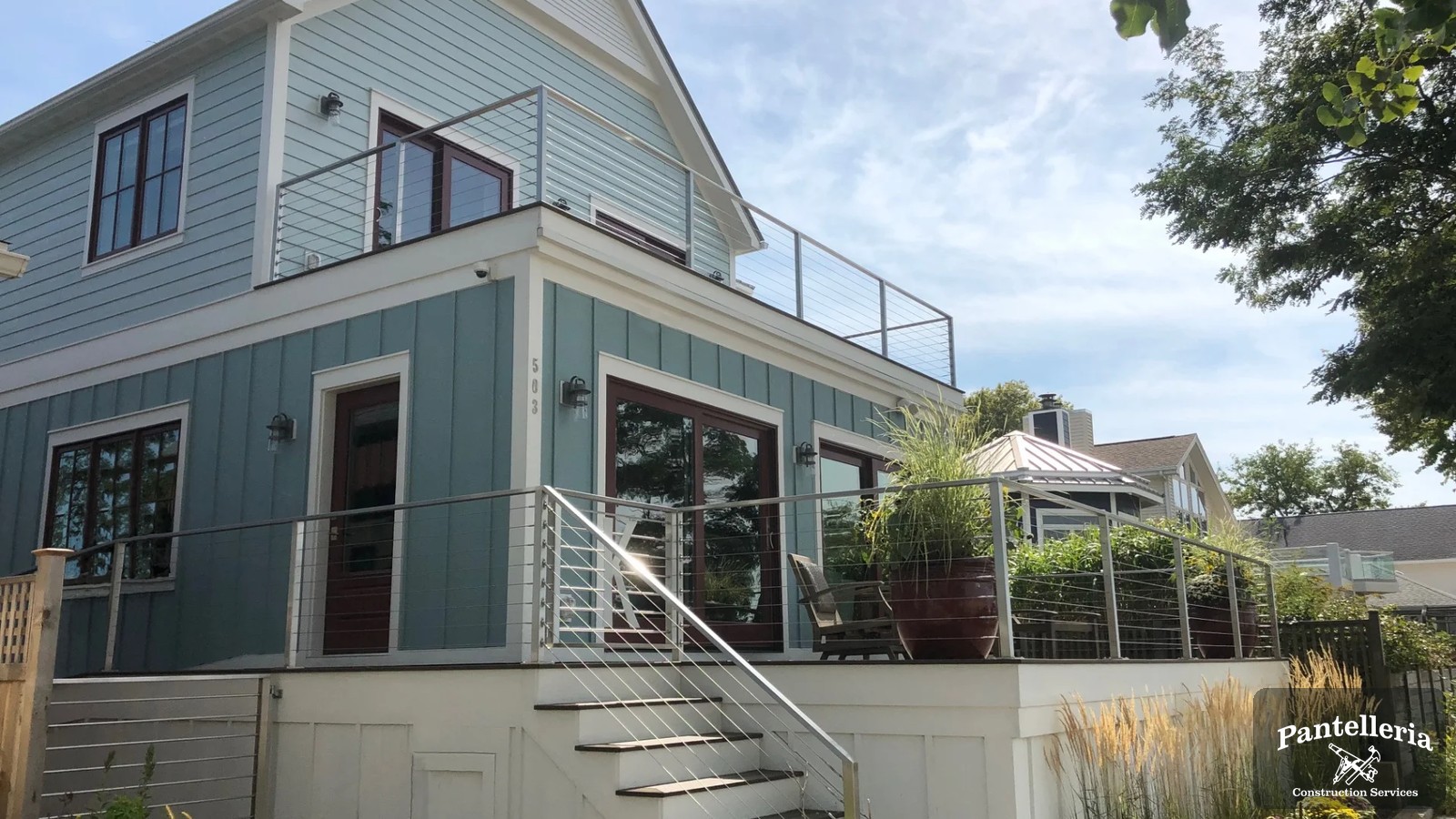Expanded blue-sided home in Southwest Michigan with a new upper-level addition and rooftop deck