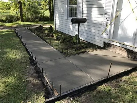 Fresh concrete walkway installation beside home by Liberty Landscape & Construction in Ventura County, CA.