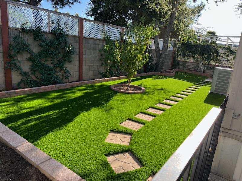 Backyard artificial grass with stepping stone path installed by Liberty Landscape & Construction in Ventura County, California.
