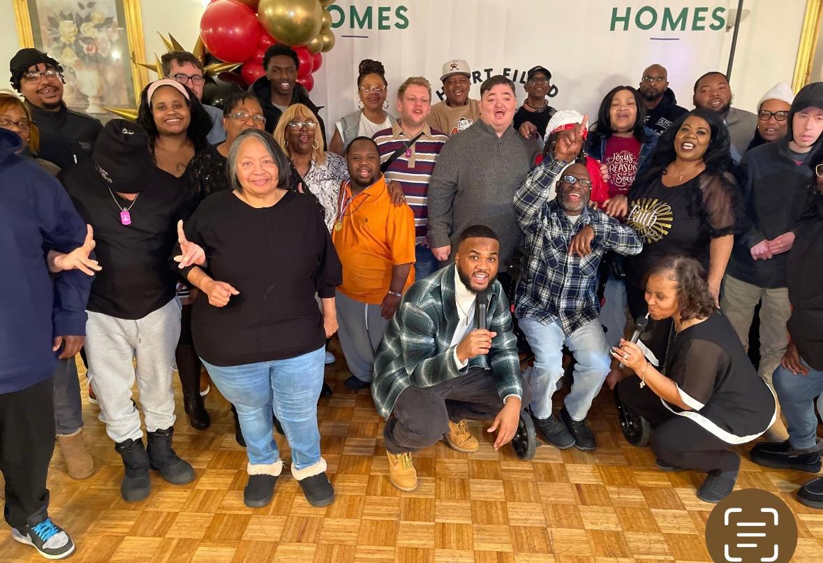 Care staff and residents smiling together in a warm living room
