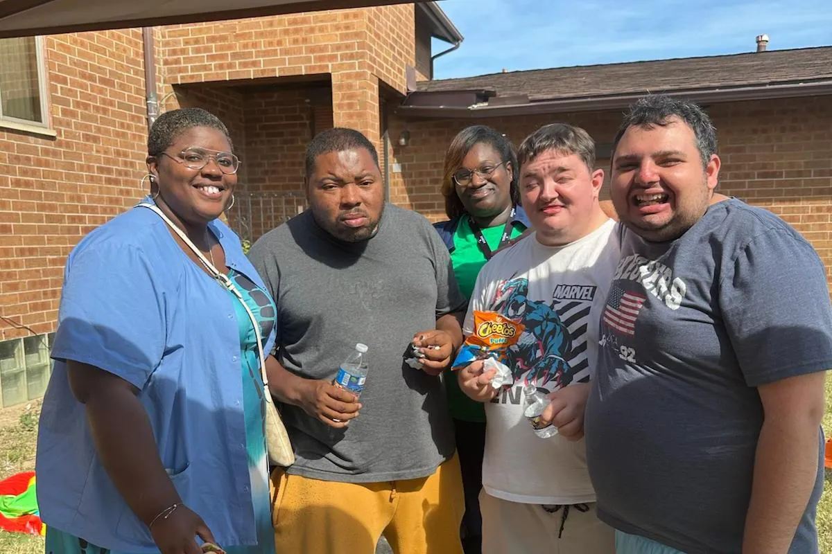 Caregiver smiling and interacting with residents in a home setting