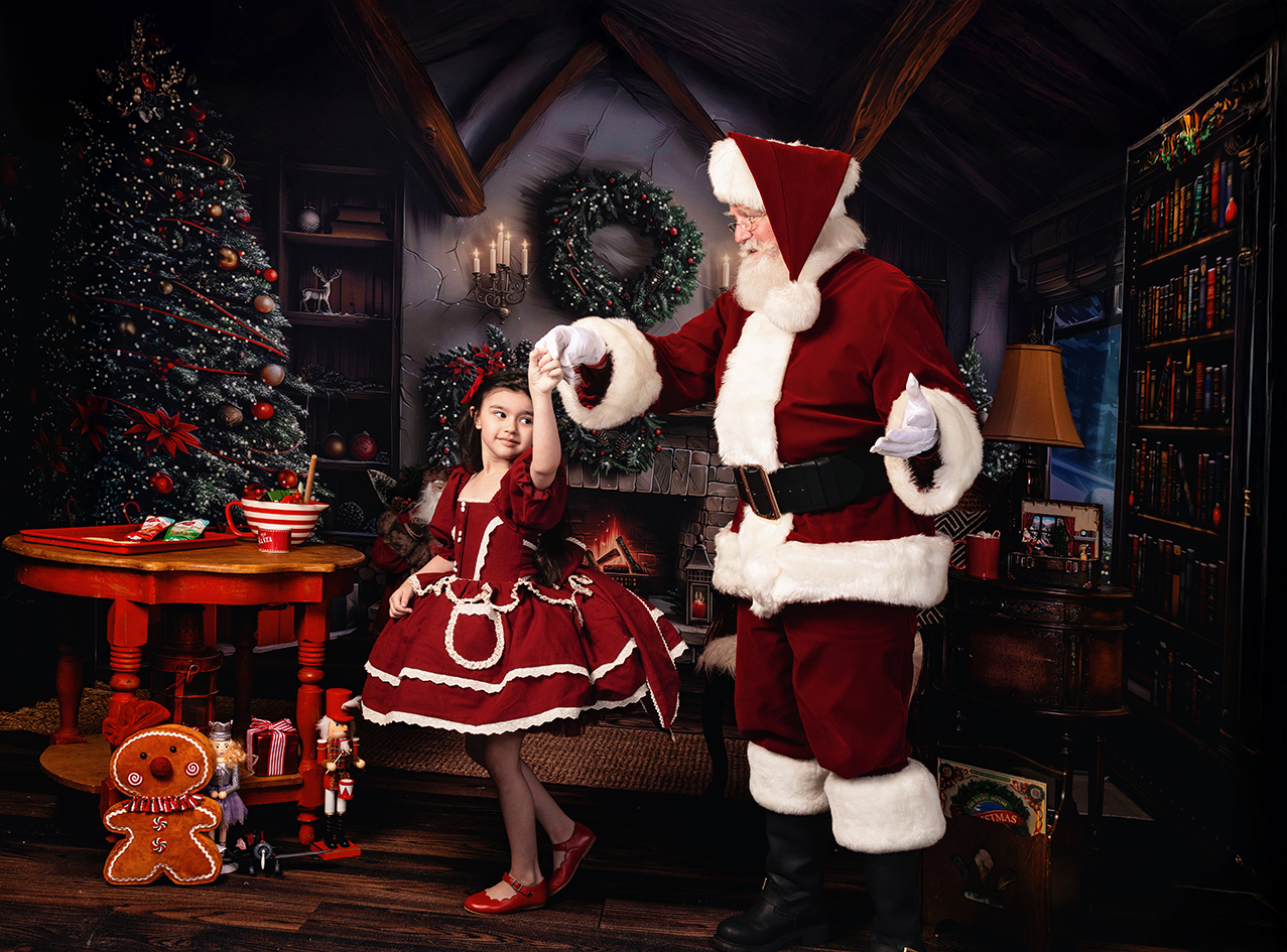 Santa and three children explore a globe together in Santa's Christmas workshop.