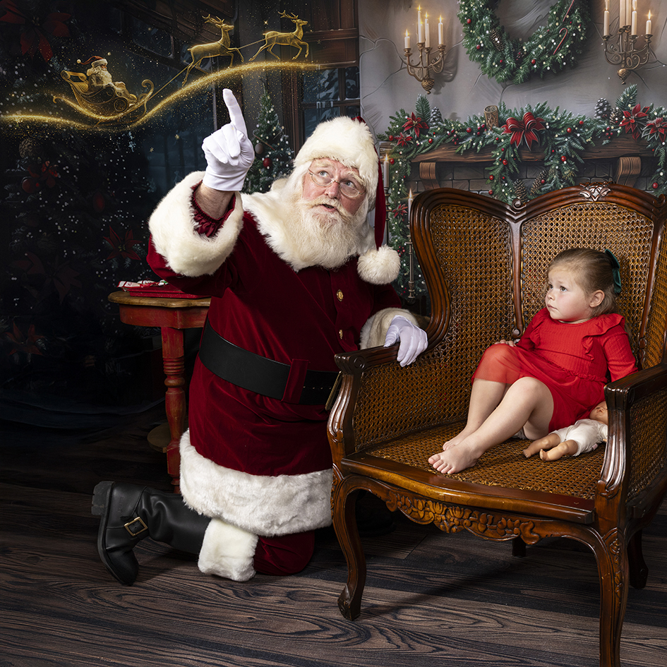 Santa shares a magical Christmas moment with a child in the workshop.