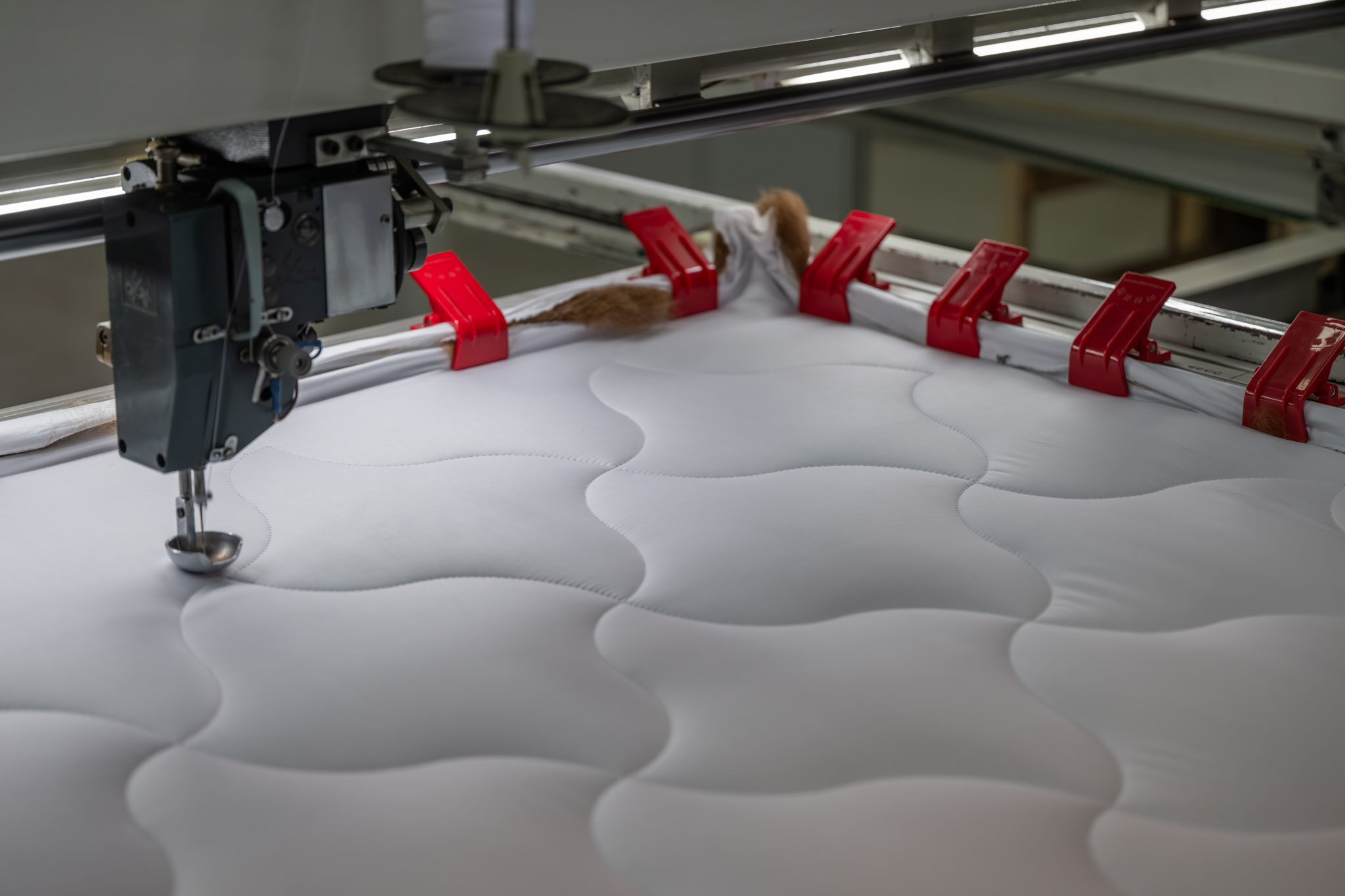 Quilting Machine that is sewing bedding from alpaca and sheep wool in high quality