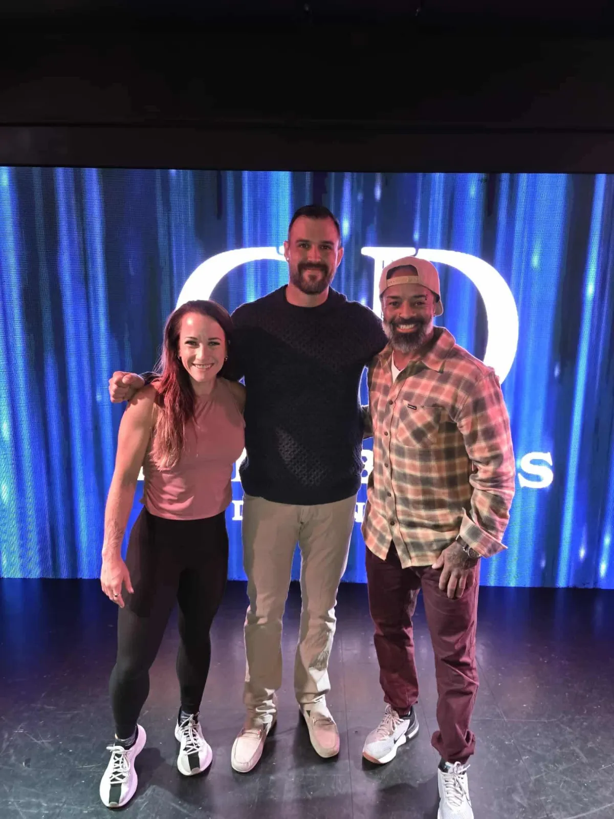 Woman jumping onto box with trainer watching