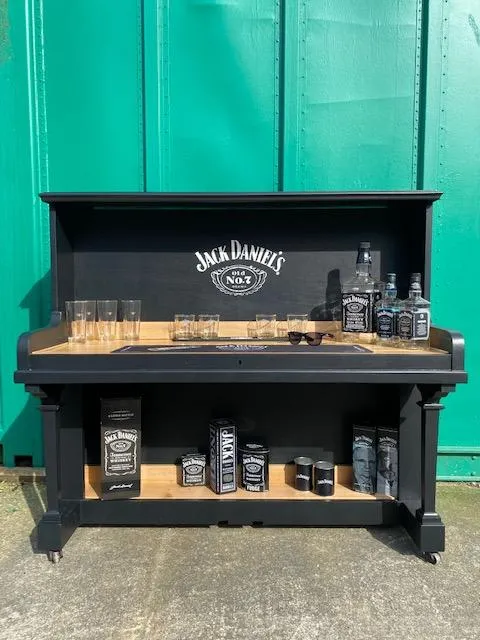 An old piano we upcycled to make into a home bar Jack Daniel's themed