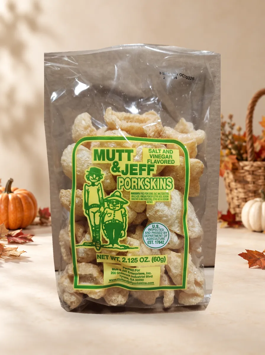 Clear plastic bag of 'Salt & Vinegar' flavored pork skins with the Mutt & Jeff logo on a green label