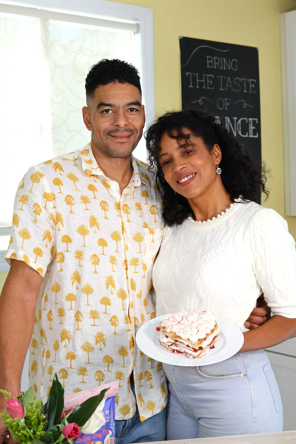 Chantal, founder of Crêpes Chantal, standing with her husband Jay while holding a homemade layered crêpe cake