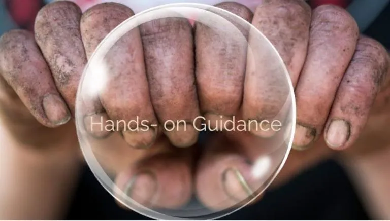 A close-up of two dirt-covered hands, symbolizing hands-on gardening guidance and practical, beginner-friendly learning. An overlay reads 'Hands-On Guidance,' emphasizing interactive, step-by-step vegetable gardening support.