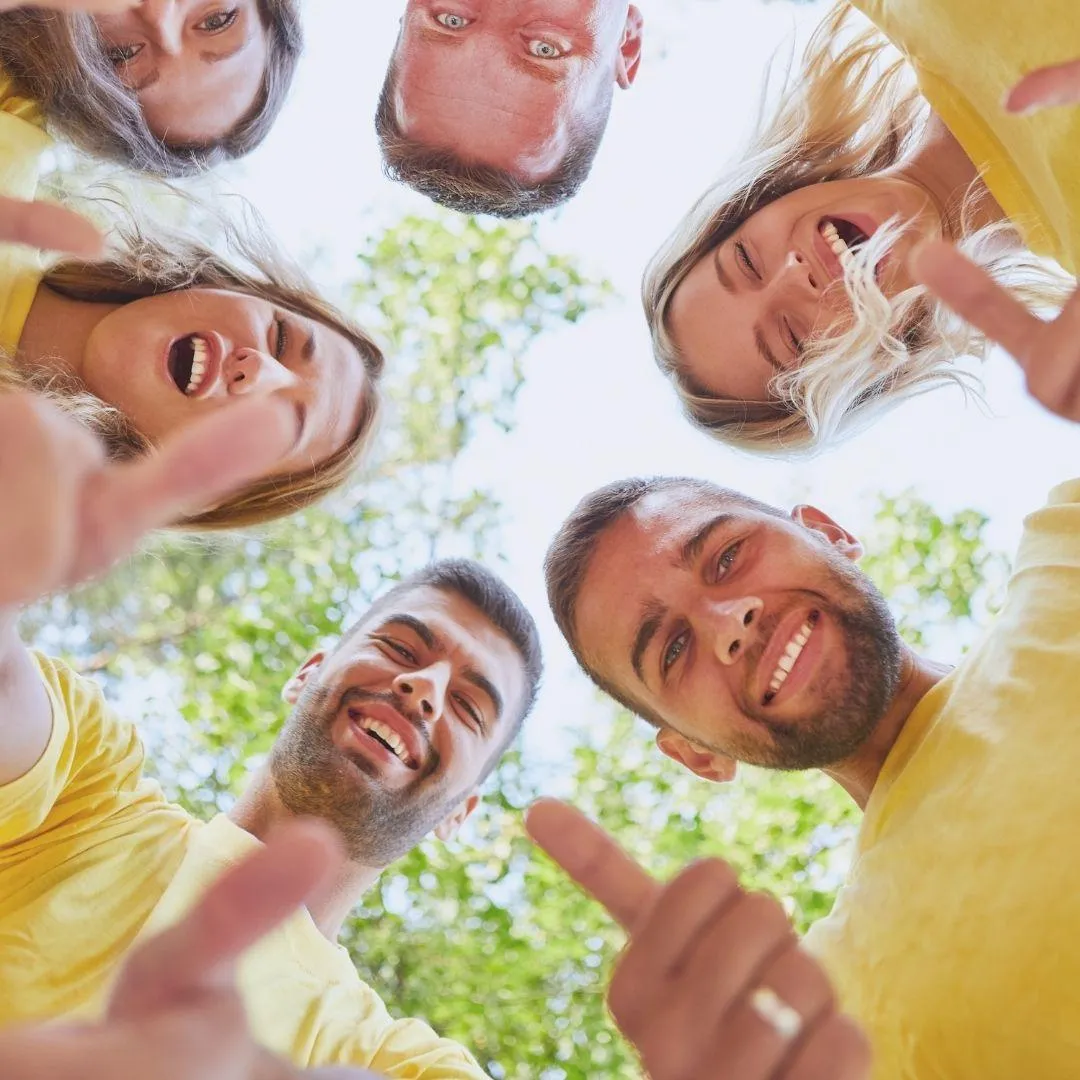  Smiling group in yellow shirts giving thumbs up.