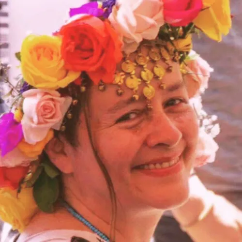A woman with a flower crown, smiling brightly.