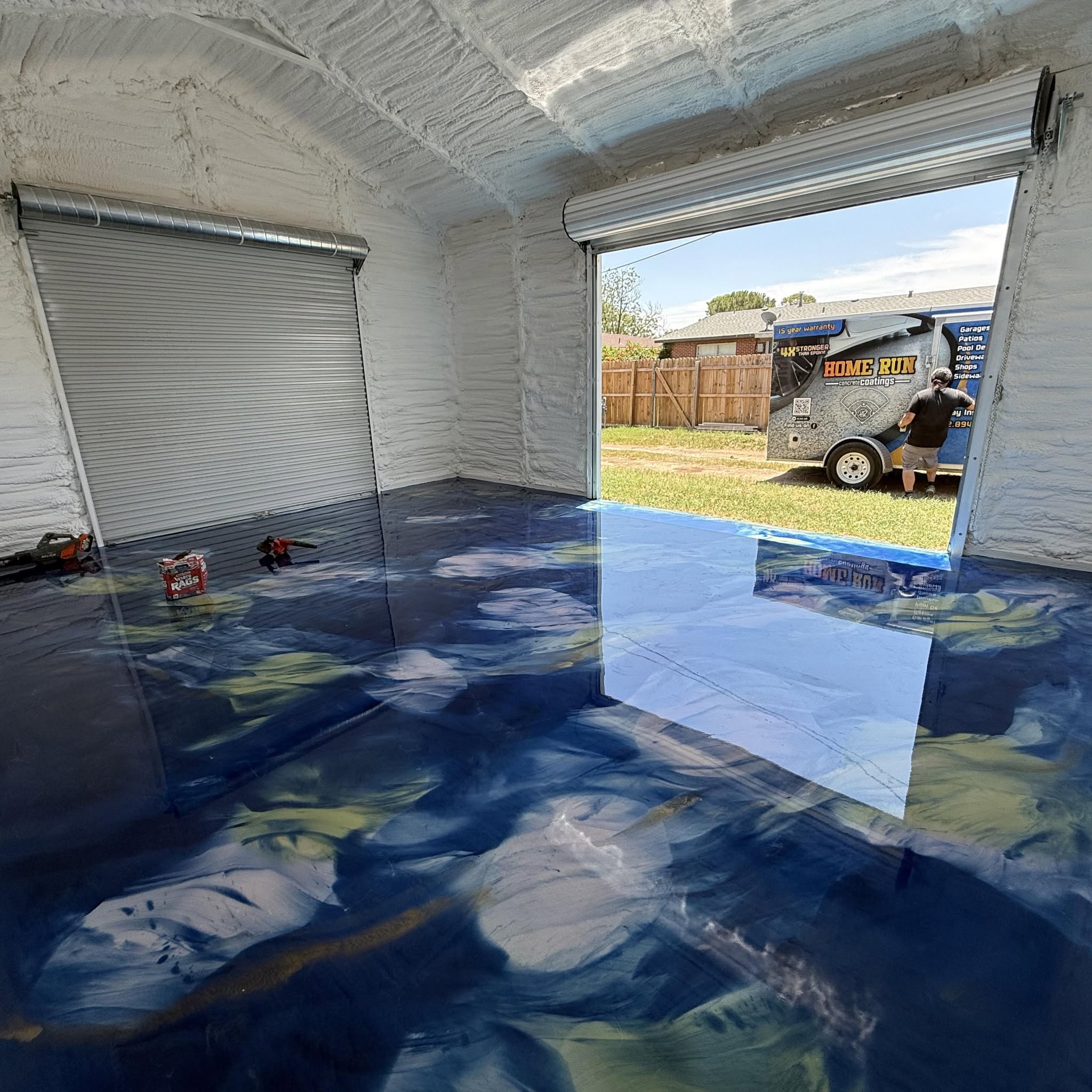 blue metallic epoxy floor in a shop with roll-up doors in Midland, TX