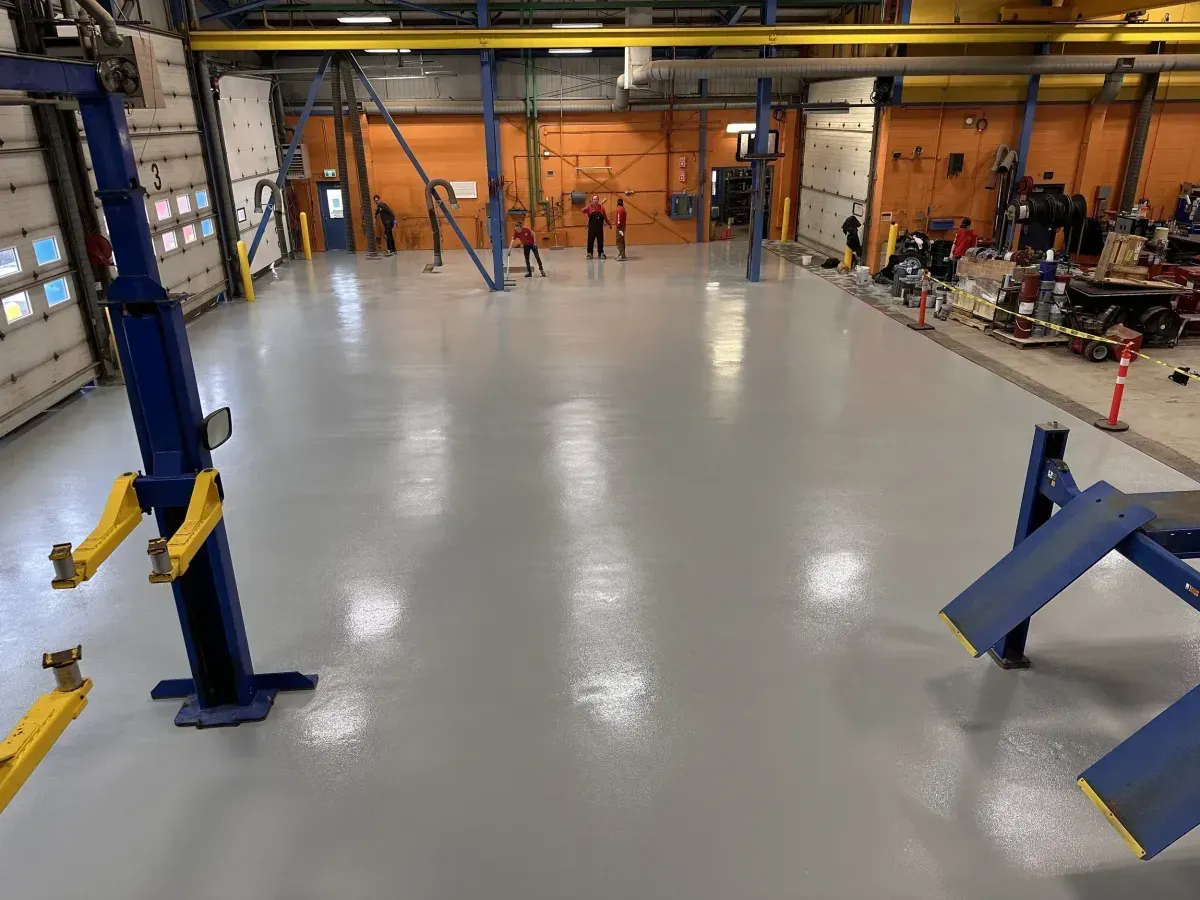 gray commercial floor coating in an auto shop with vehicle lifts in Odessa, TX