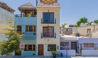 Person signing an escrow agreement for a real estate purchase in Mexico, with contract documents and a pen on a desk during the property closing process. Dream Baja Realty