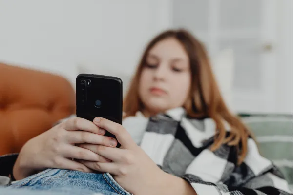girl holding cellphone as she waits for a response