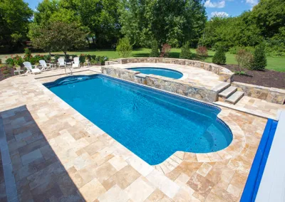 A person sitting in a swimming pool with an umbrella