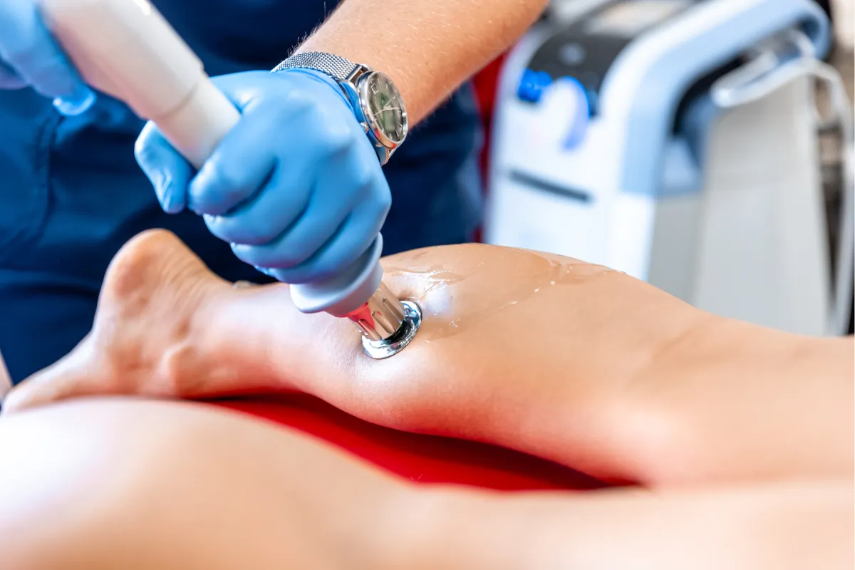 Physical Therapisc performing shockave therapy on patients calf