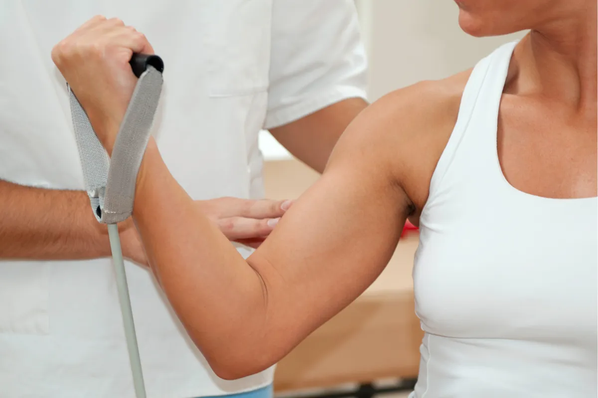 Psysical Therapist assisting woman with bicep curl