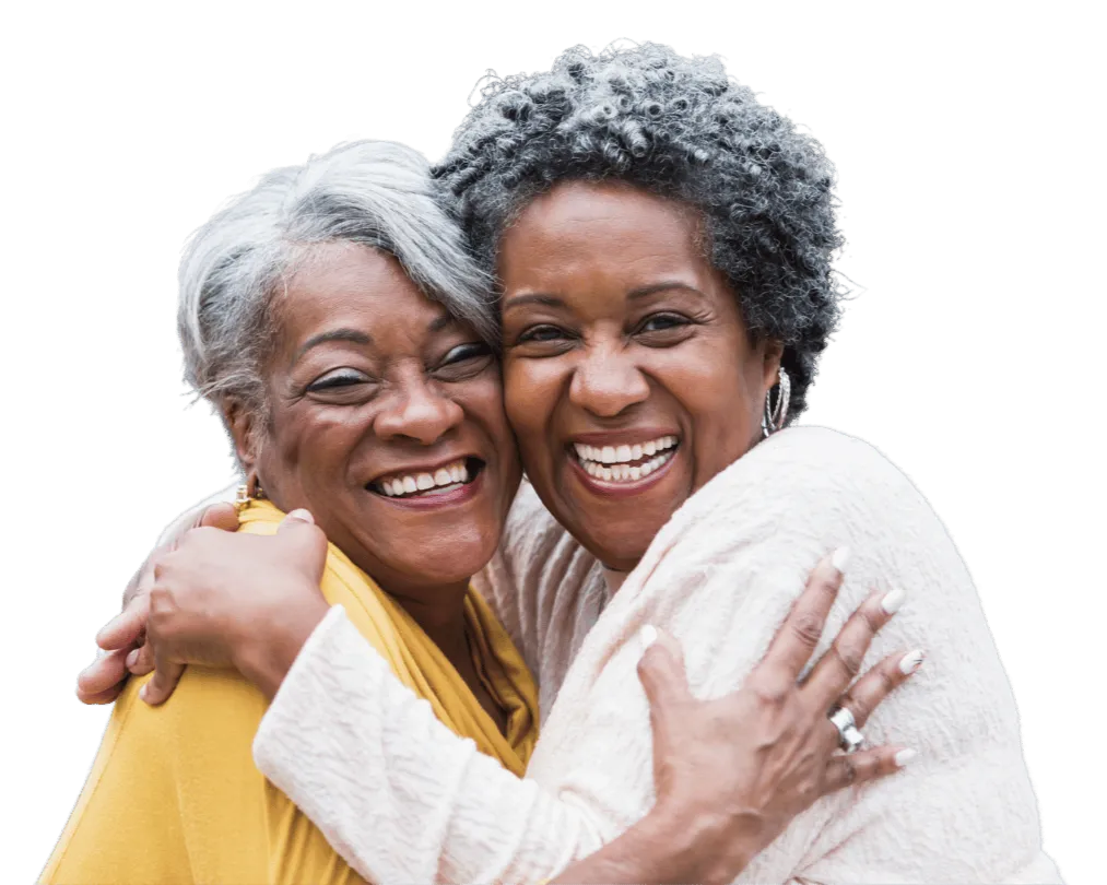 Two joyful senior women embracing and smiling, representing emotional support and connection in the context of senior downsizing and relocation services.