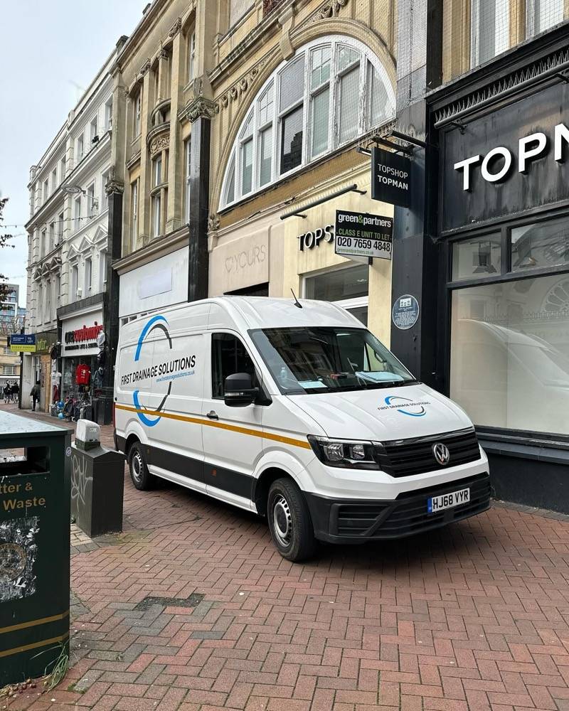 UK Drain Services van parked in front of Topman for a drainage job