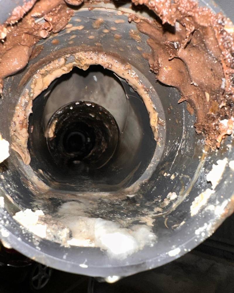 Close-up of a severely corroded commercial drainage pipe requiring repair
