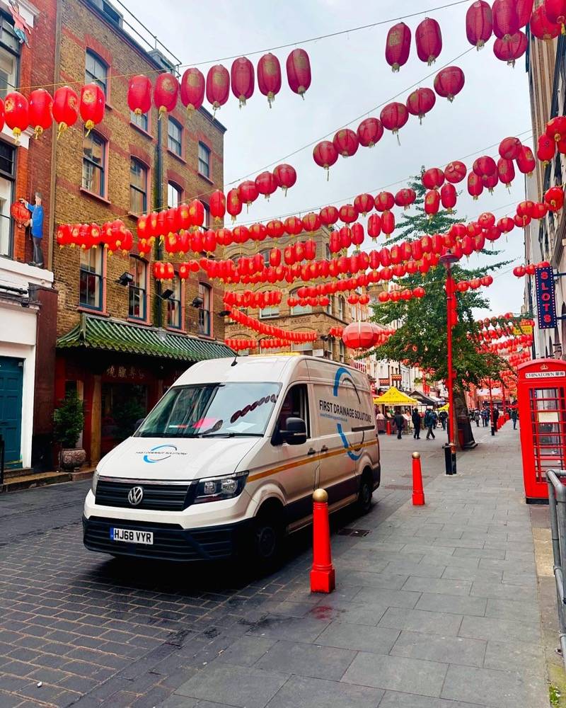 UK Drain Services van parked in London Chinatown under red lanterns at night