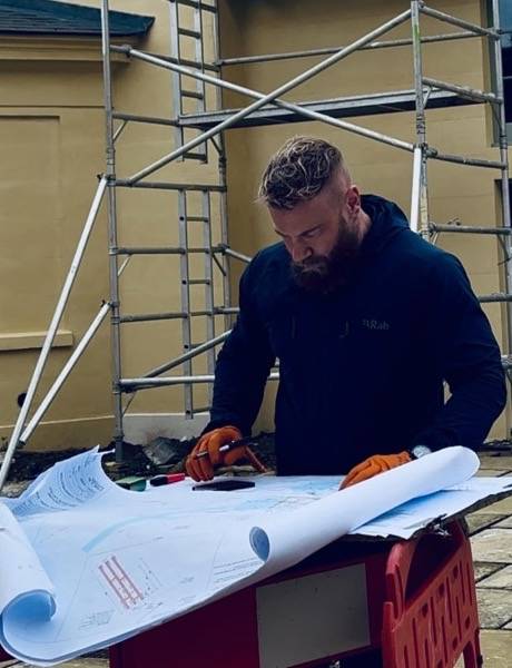 UK Drain Services engineer reviewing drainage plans on a commercial site