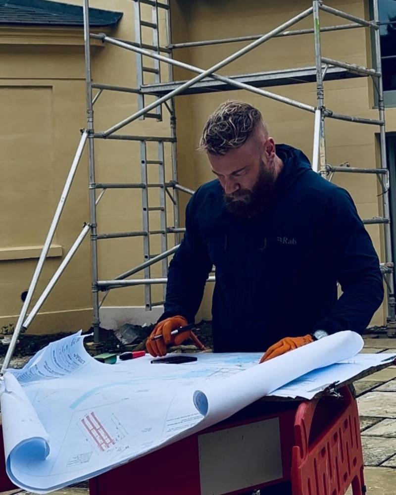 UK Drain Services engineer reviewing drainage plans on a commercial construction site