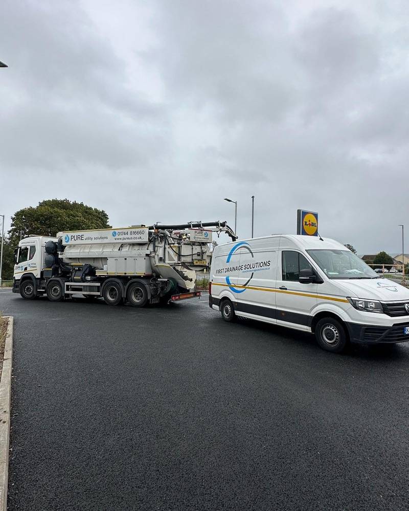 UK Drain Services van and truck parked in front of Lidl during a drainage job