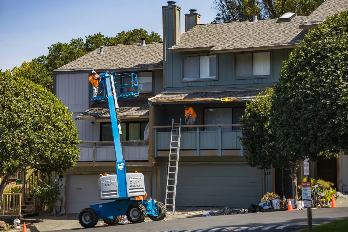 Remodeling contractors working outside a Los Angeles home under renovation