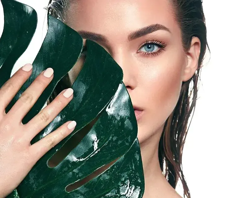 person holding clear glass bottle