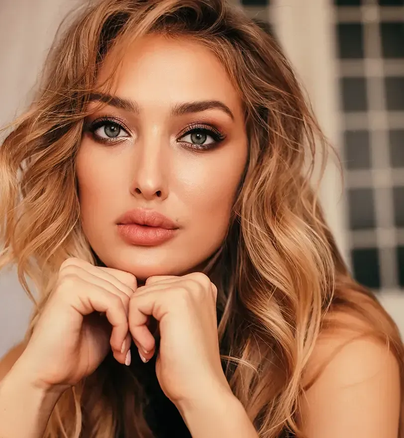 person holding clear glass bottle