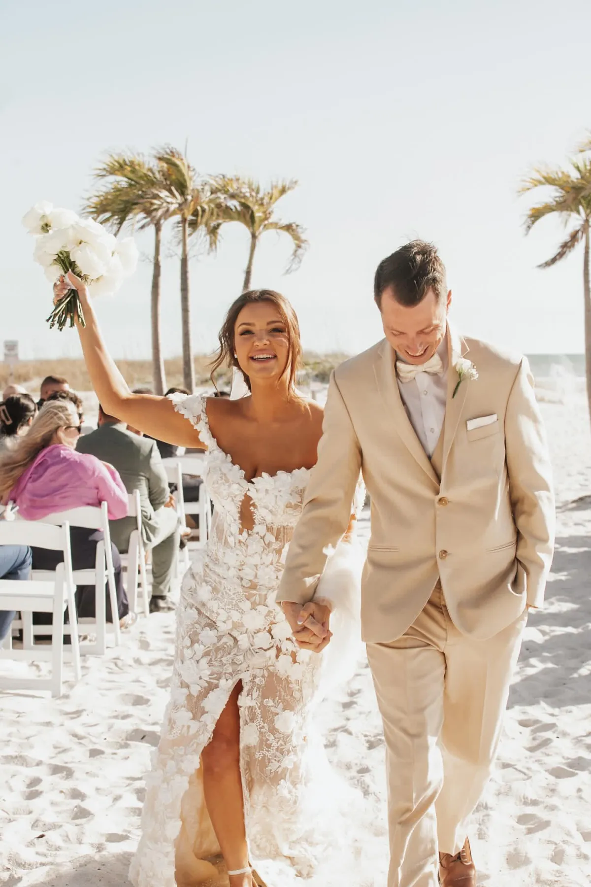 Bride and groom walking up a Florida beach wedding aisle under palm trees