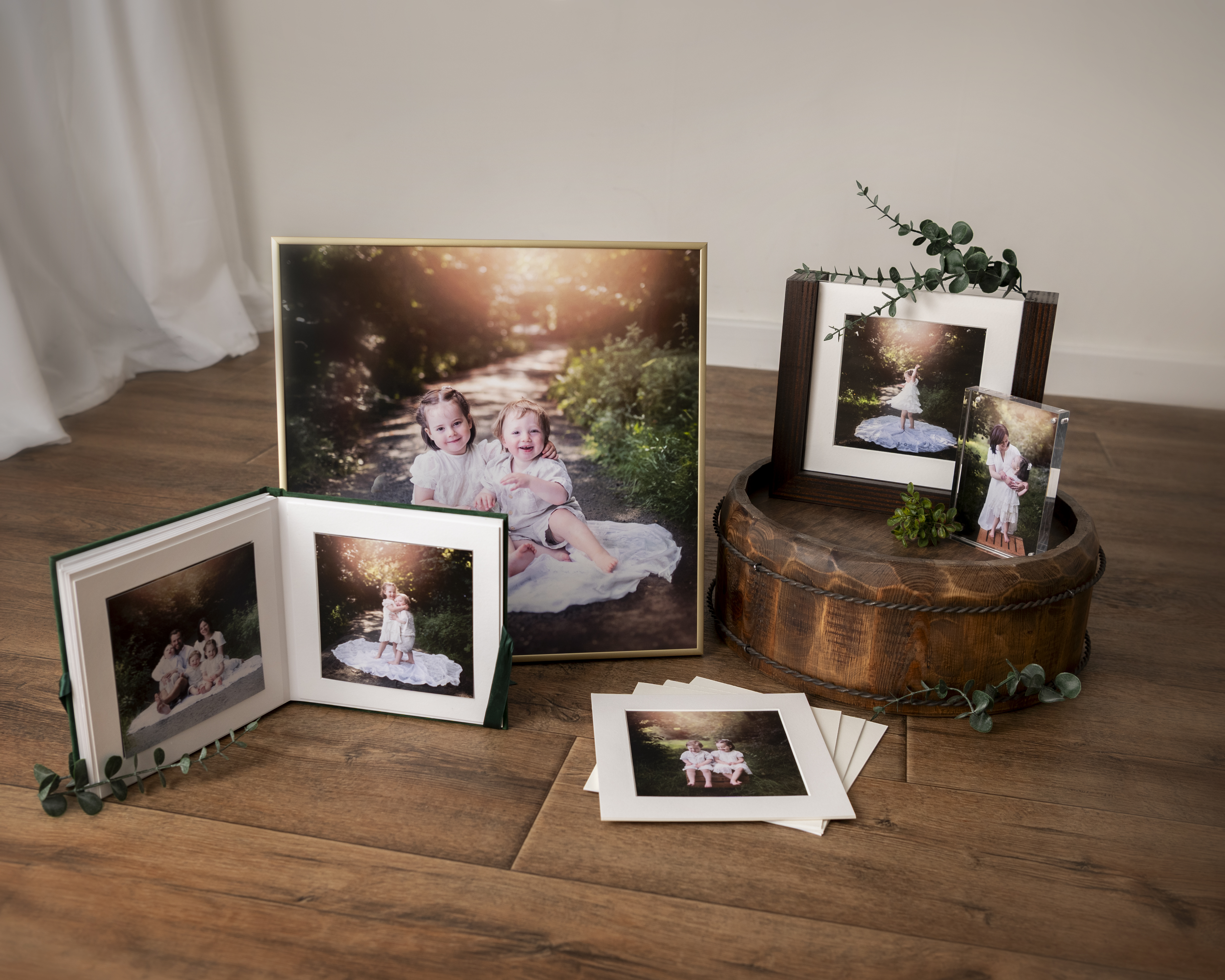 Fotoprodukter från Little Moments by Felicia med trädisplay, printar och inramade familjebilder.