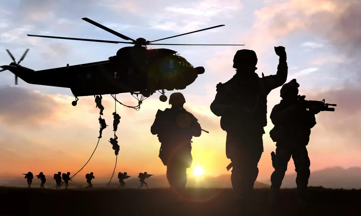 Soldiers rappelling from a helicopter
