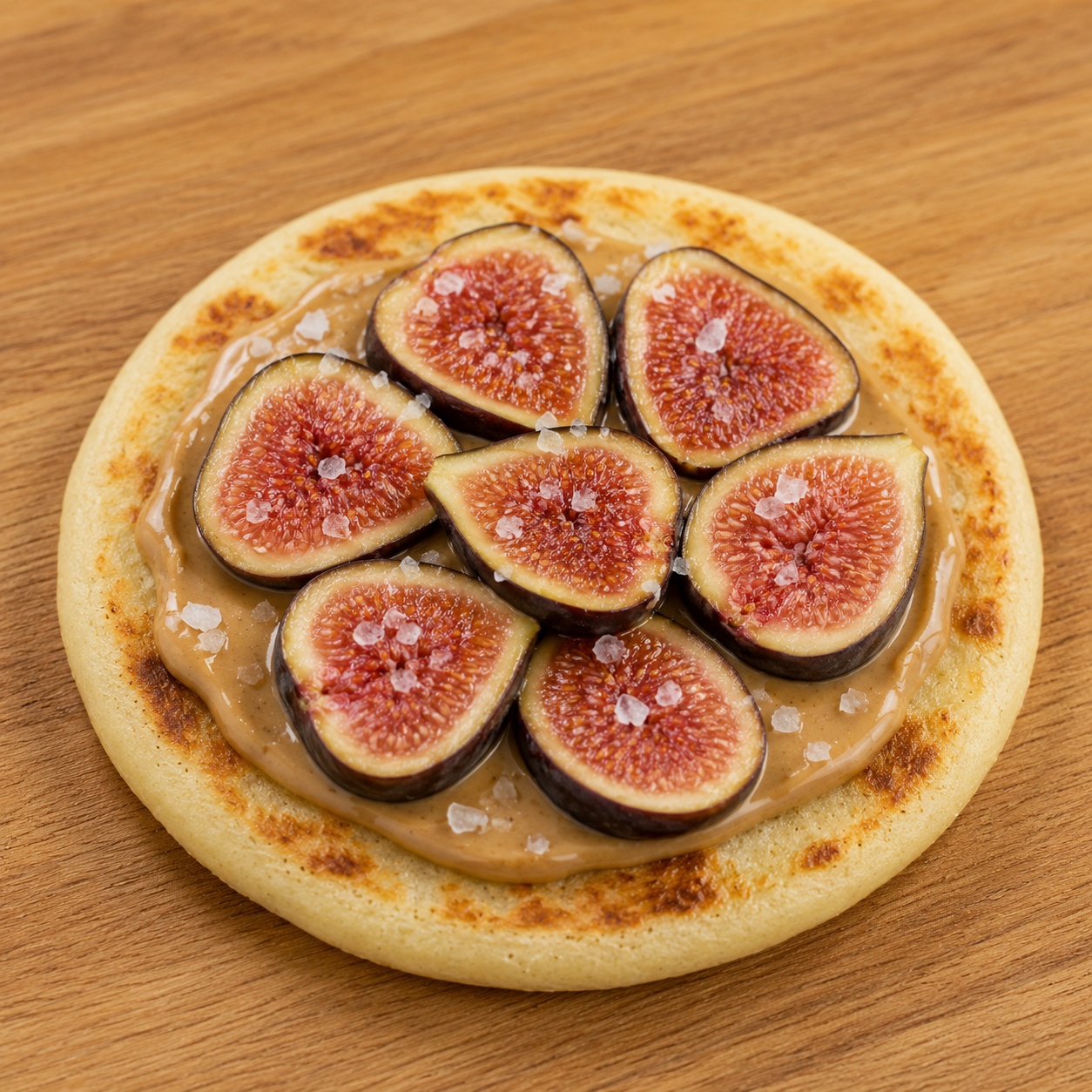Arepa spread with cashew butter, sliced fresh figs and flaky salt